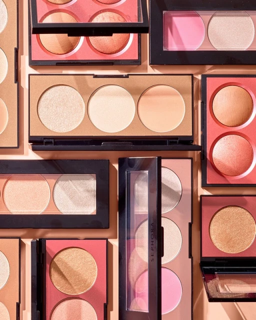 Overhead shot showcasing a variety of makeup palettes featuring blush, highlighter, and bronzer compacts, neatly arranged on a neutral backdrop.