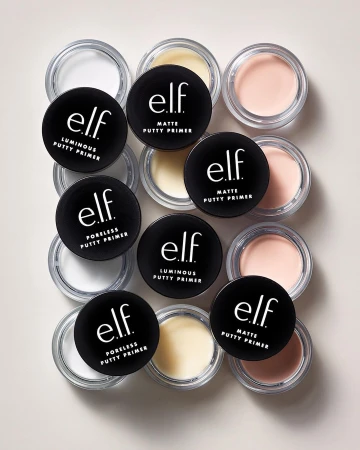Close-up of assorted e.l.f. putty primers in their containers, including matte, luminous, and poreless varieties, on a neutral surface.