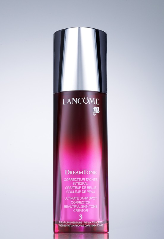 Lancôme DreamTone dark spot corrector bottle on a grey background. Beauty and personal care product shot in studio with studio lighting.