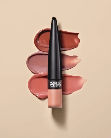Lip product tube standing vertically centered over three horizontal cosmetic swatches on beige background