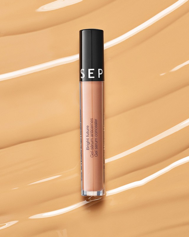 Sephora Bright Future Gel Serum Concealer tube displayed on a textured light brown background, cosmetics, beauty product.