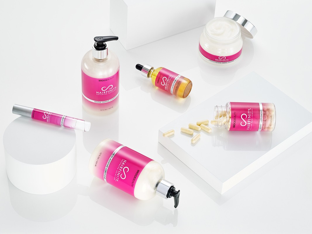 Hairfinity hair care product collection featuring shampoo, conditioner, hair serum, cream, and vitamin supplements on a white background.