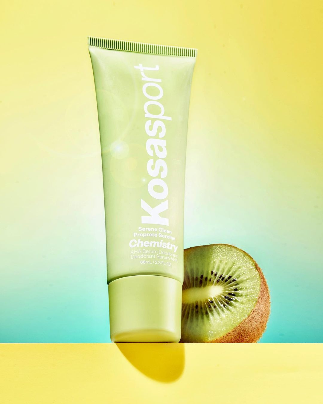 Kosasport Chemistry deodorant product shot with kiwi. Green and yellow studio background highlighting the skincare product.