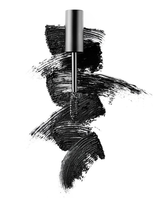 Mascara wand with black mascara smears on a white background, eye makeup product shot for beauty and cosmetics advertising.
