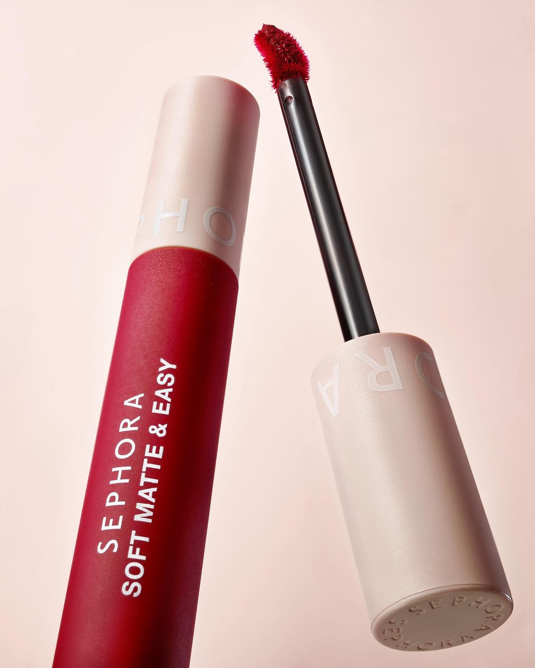 Close-up of Sephora Soft Matte & Easy lip product, featuring a red lipstick tube and applicator against a soft pink background.