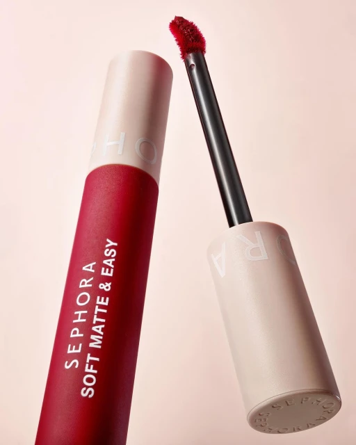 Close-up of Sephora Soft Matte & Easy lip product, featuring a red lipstick tube and applicator against a soft pink background.