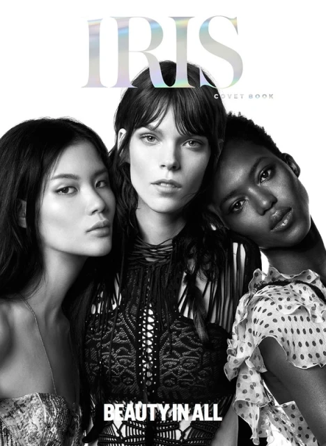 Black-and-white magazine cover featuring three diverse women with distinct hairstyles and makeup, against a stark white backdrop. 