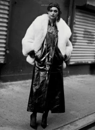Model in a long black trench coat with a voluminous white fur jacket styled by Marc Anthony George in Los Angeles