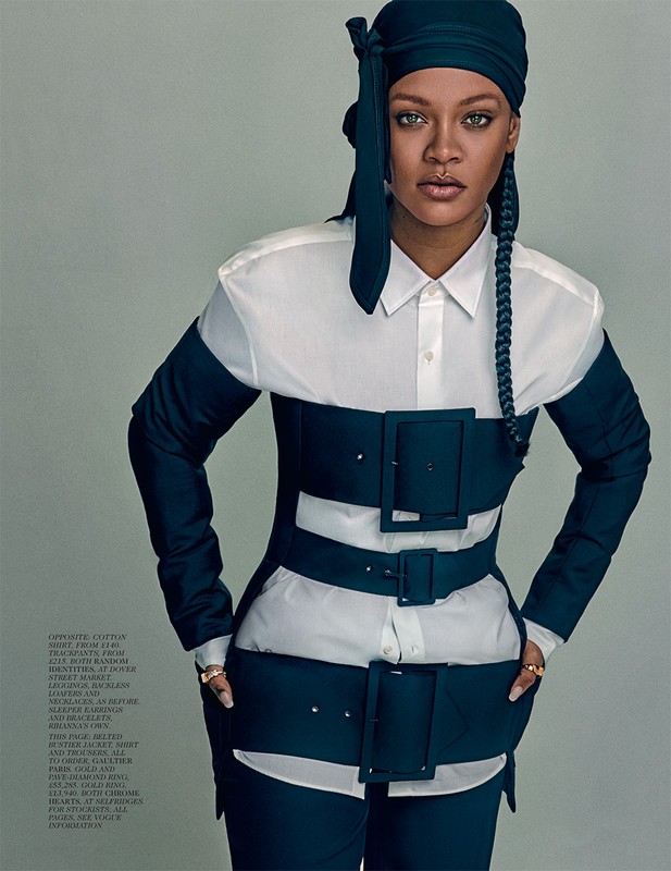 Portrait of Rihanna wearing a white collared shirt, teal headscarf, and a teal corset-like belt with large buckles, posing in studio.