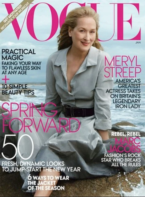 Vogue magazine cover featuring Meryl Streep in a gray dress, sitting on a rock at the beach, with bold pink typography.