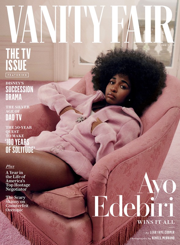 Ayo Edebiri on Vanity Fair cover: A woman with afro hair wearing a pink tracksuit reclines in a pink armchair by a window.