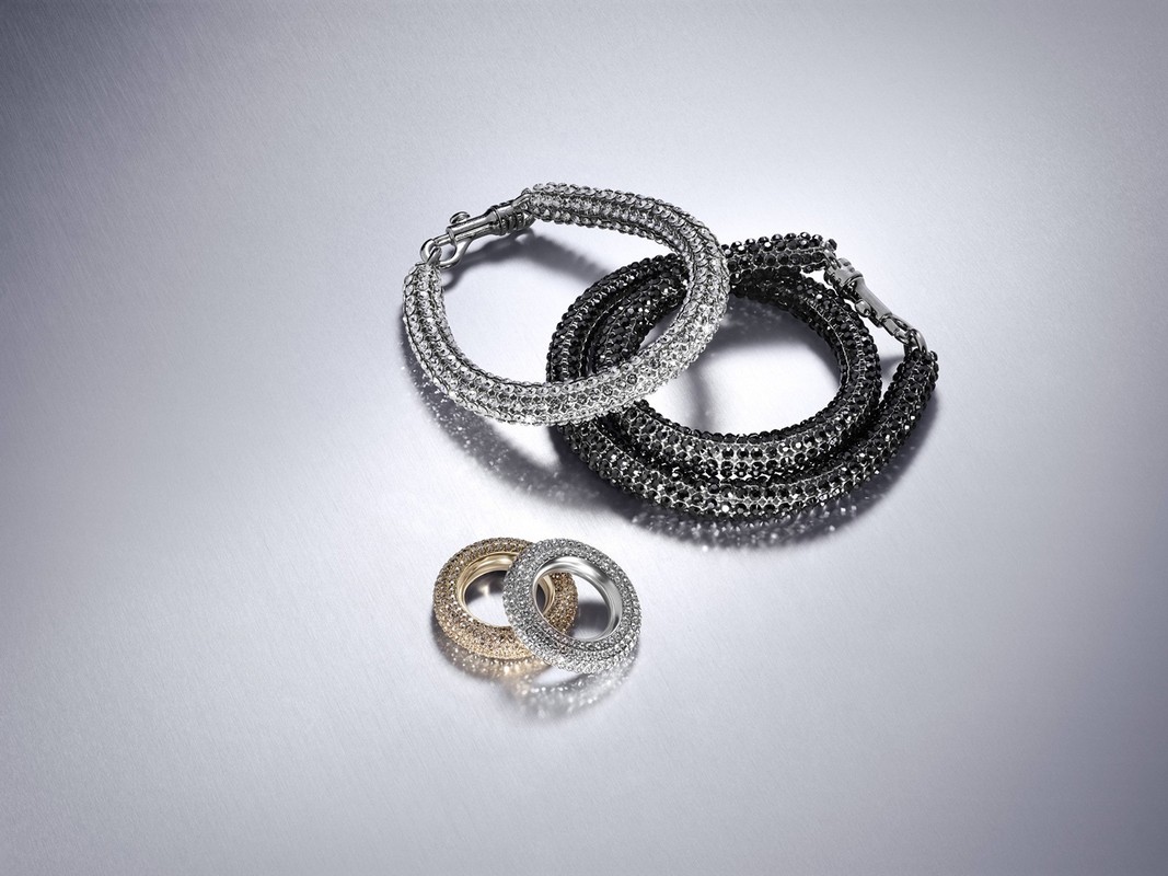 Silver and gold bracelets featuring a sparkly design against a shiny silver background, captured in a studio setting.