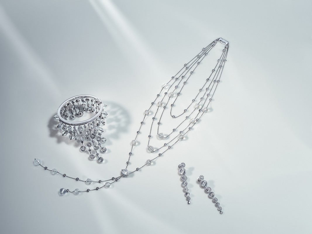 Elegant jewelry set featuring a bracelet, necklace, and earrings with clear gemstones on a clean white surface with diffused lighting.