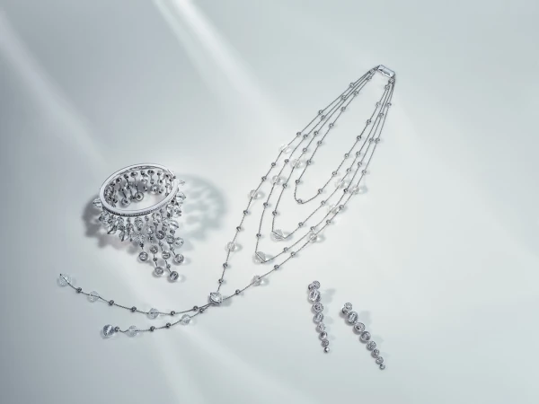 Elegant jewelry set featuring a bracelet, necklace, and earrings with clear gemstones on a clean white surface with diffused lighting.