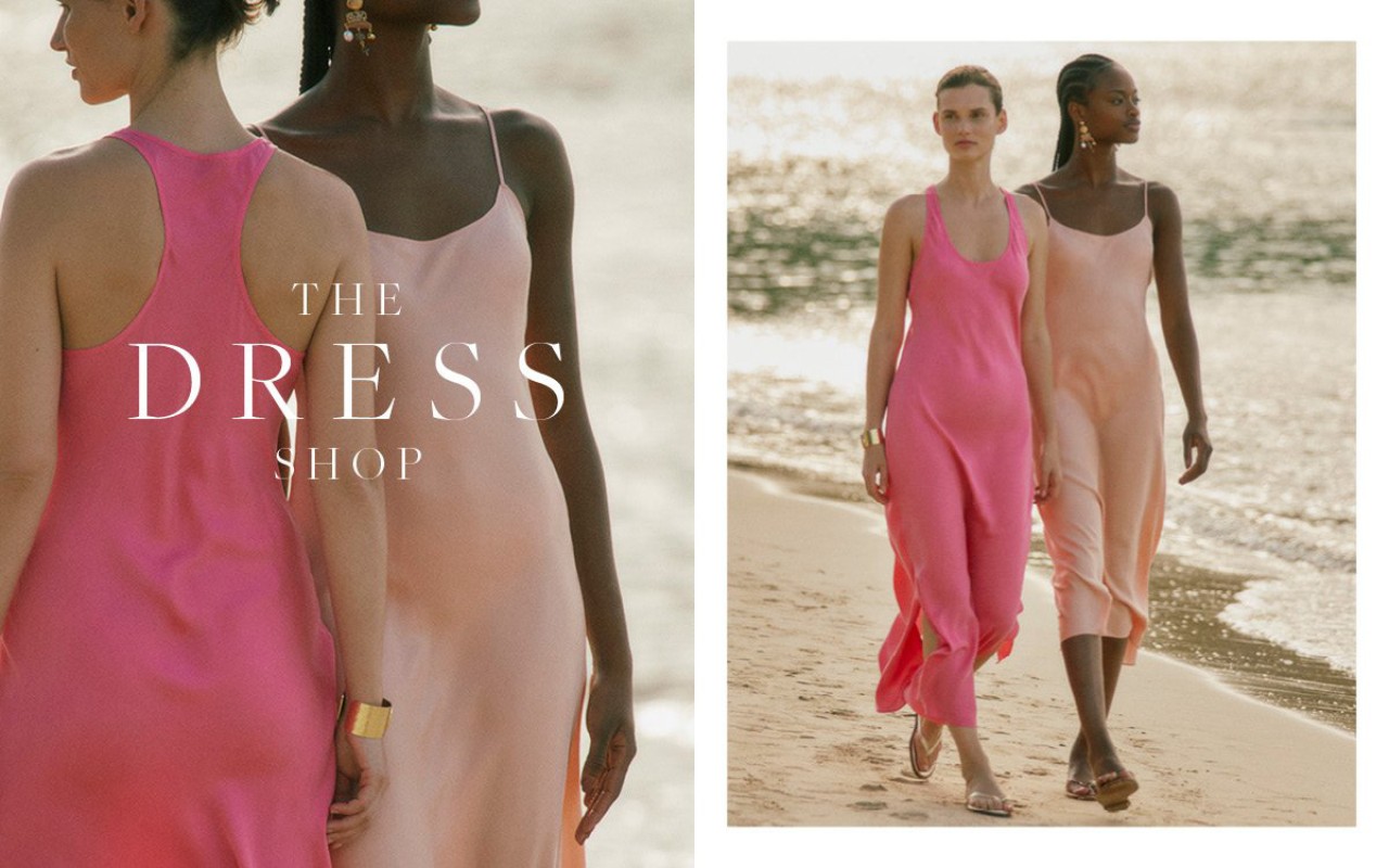 Two female models wearing slip dresses walking along a sandy beach with ocean waves visible in the background