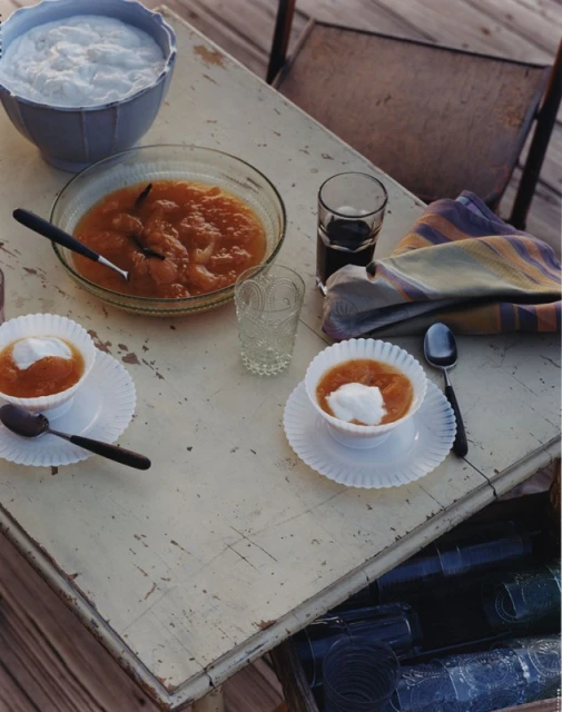 Overhead shot of a table set with dessert bowls, glassware, a cloth napkin, and silverware; food photography, home setting.