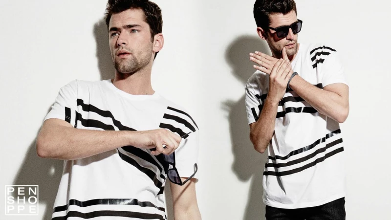 Two fashion models wearing striped white t-shirts against a plain white background with studio lighting.