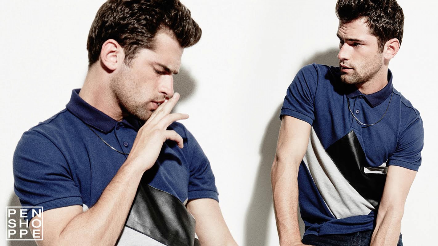 Studio shot of a handsome adult male in a blue polo shirt with a modern design element, captured against a bright white backdrop.