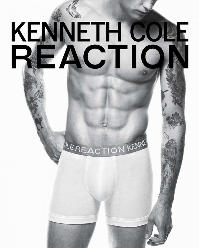 Male model torso shot in underwear, tattooed arms, Kenneth Cole Reaction branding, black and white image on a white backdrop.