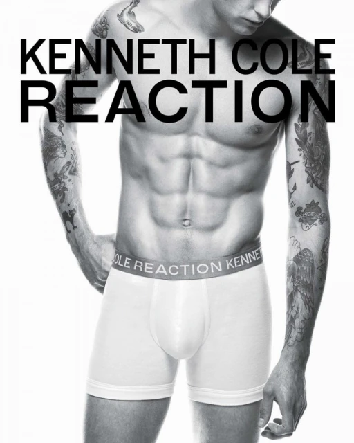 Male model torso shot in underwear, tattooed arms, Kenneth Cole Reaction branding, black and white image on a white backdrop.
