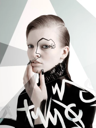 A young adult female model poses with black and white body paint, nail polish, lace collar, and slicked-back hair in front of a geometric background.
