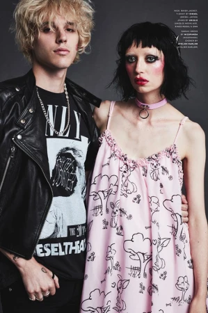 Portrait of two models with edgy styling, a man in a black leather jacket and a woman in a pink patterned dress.