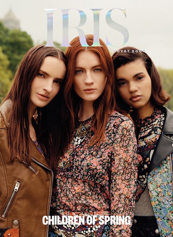 Three female models with styled hair posing together outdoors with printed tops and jackets