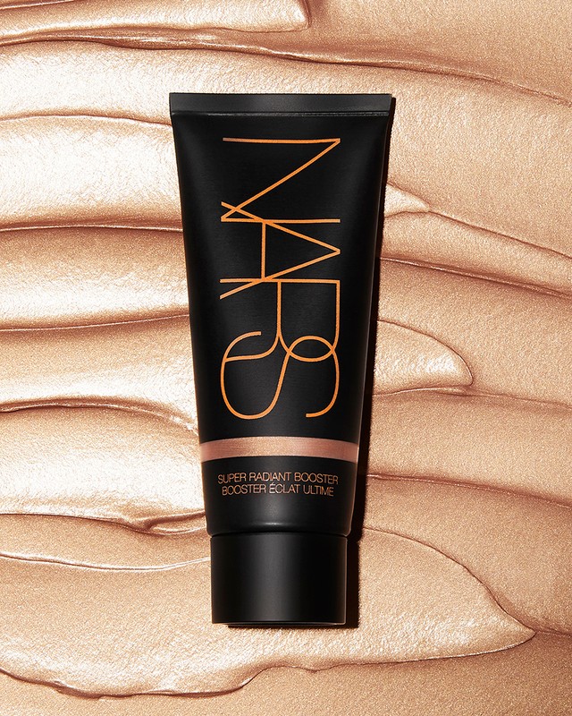 Black NARS Super Radiant Booster Eclat Ultime tube against a bronze shimmering textured background. Studio lit, product shot.