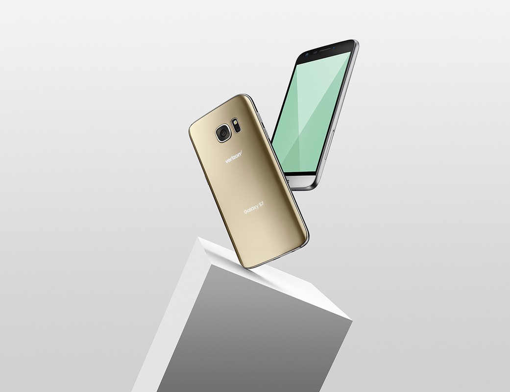 Two smartphones, one gold and one silver, float in a studio-lit scene, positioned above a white geometric block against a gradient background.
