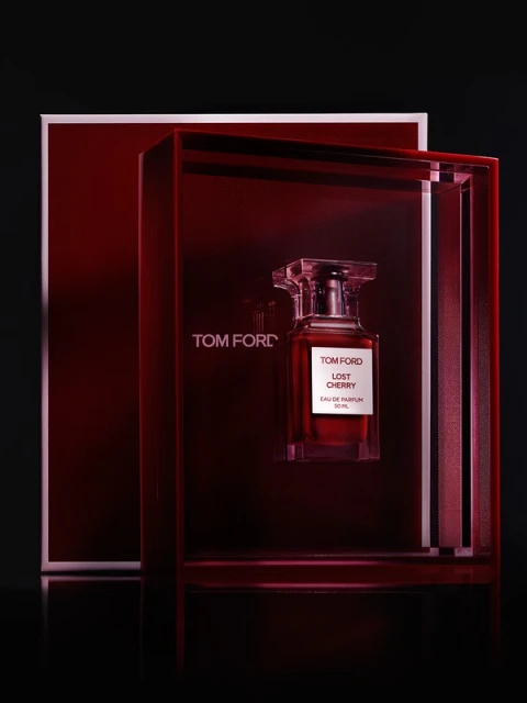 Tom Ford Lost Cherry perfume bottle displayed in its original box, set against a dark background in a studio setting. 