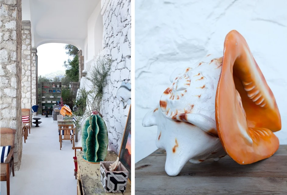 Indoor patio with stone pillars leads to outdoor area, featuring decorative cactus, shell sculptures, and white stone wall backdrop.