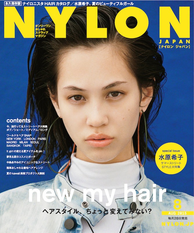 Magazine cover featuring a portrait of an adult female with short black hair and hoop earrings, wearing a denim jacket and turtleneck.