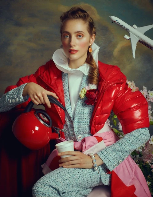 Woman in fashionable red puffer jacket and tweed suit pouring tea, with a toy airplane and floral elements in a painterly setting.