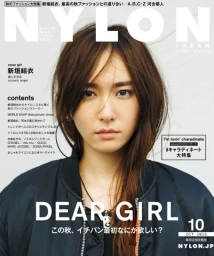 Portrait of a young Japanese woman with dark hair wearing a black bomber jacket against a plain white background for Nylon Japan.