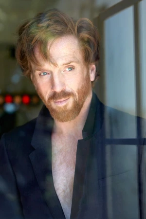 Portrait of a man with red hair and beard wearing a dark jacket photographed by Mona Kuhn