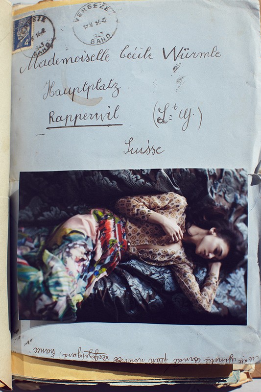 Photograph of a young woman in a patterned top and skirt reclining on a patterned surface, affixed to a vintage envelope.