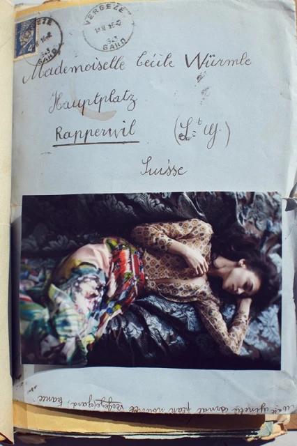 Photograph of a young woman in a patterned top and skirt reclining on a patterned surface, affixed to a vintage envelope.