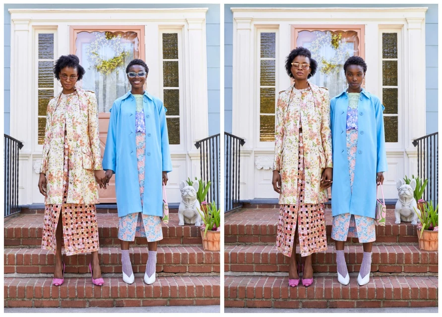 Two African-American women in floral dresses and pastel coats holding hands on brick steps in front of a light blue house with a pink door.