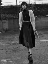 Model in dark turtleneck and pleated midi skirt standing outdoors in Los Angeles shot by stylist Morgan Gibbons
