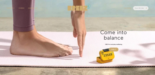 Bare feet on a pink yoga mat with a small yellow tin and website text overlaid