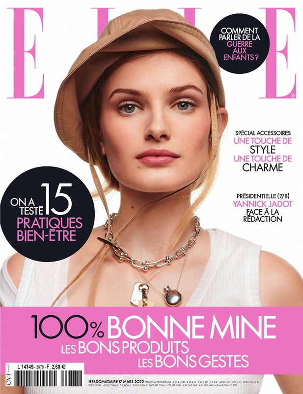 Magazine cover featuring a portrait of a model wearing a tan bucket hat and a silver necklace, with 'ELLE' masthead in pink.