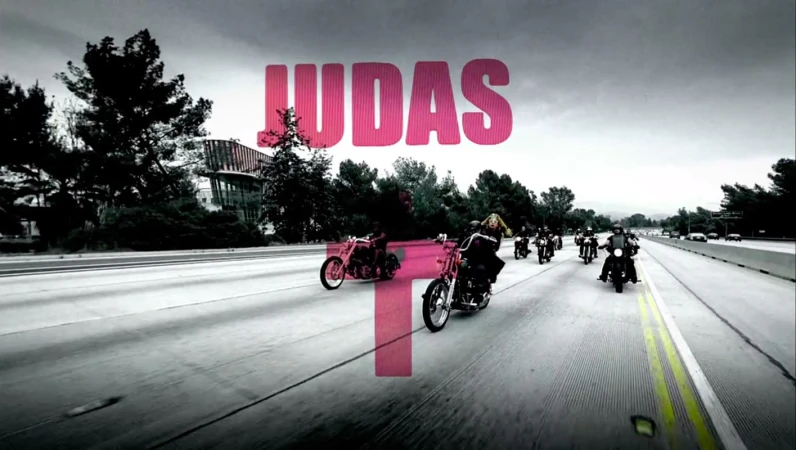 A group of motorcyclists ride in formation on a highway under an overcast sky, with trees and a modern building visible in the background.
