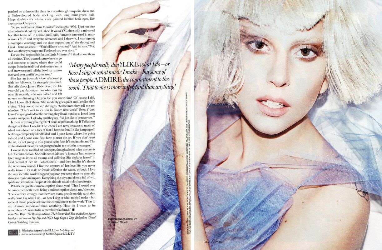Editorial shot of fair-skinned adult female model with blonde hair, light eye makeup, and light pink lipstick, wearing a light blue tulle dress.