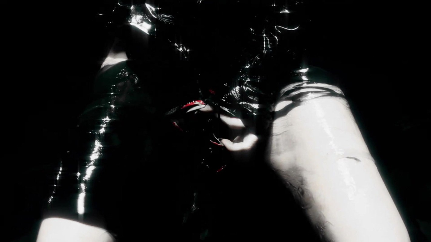 Abstract photo of a person in a dark, wet environment, possibly underwater, emphasizing glossy textures and dark lighting.