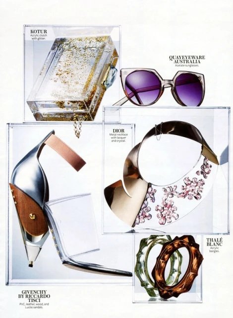 Fashion editorial featuring an acrylic clutch with glitter, sunglasses, metal necklace, open toe heels, and acrylic bangles displayed in clear boxes.