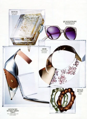 Fashion editorial featuring an acrylic clutch with glitter, sunglasses, metal necklace, open toe heels, and acrylic bangles displayed in clear boxes.