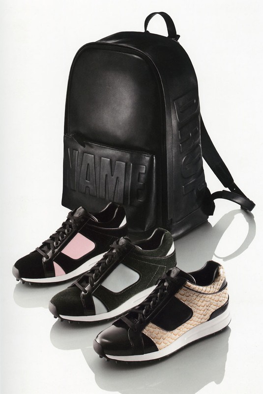 Black backpack and three pairs of low-top sneakers with black, pink, silver, and snake-skin pattern leather accents on a white background.
