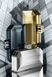Three faceted crystal clutch bags styled in a vertical stack against a modern glass building facade.