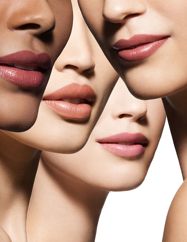 Close-up of four women with diverse skin tones showcasing various shades of lipstick, emphasizing beauty and cosmetic appeal.