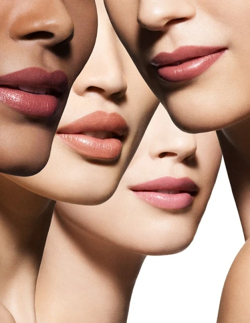 Close-up of four women with diverse skin tones showcasing various shades of lipstick, emphasizing beauty and cosmetic appeal.